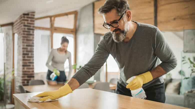 Man and woman cleaning kitchen 