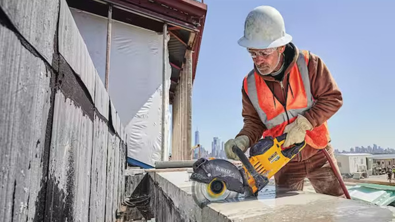 A consturction worker using a heavy-duty DeWalt tool with a Flexvolt battery