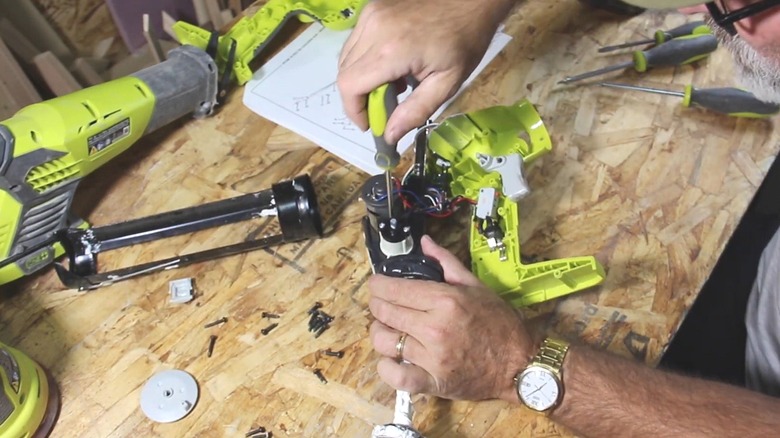 Person fixing a broken Ryobi Tool