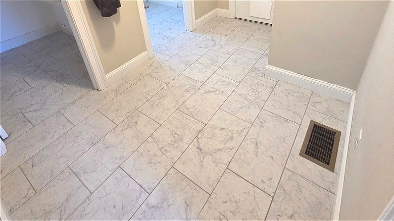 Tile flooring with white marble-look tiles set in a 1/3 offset pattern