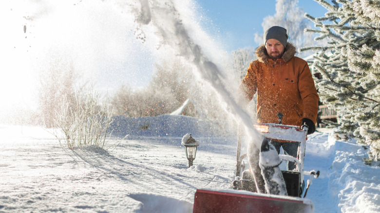 Man snow blowing a sidewalk