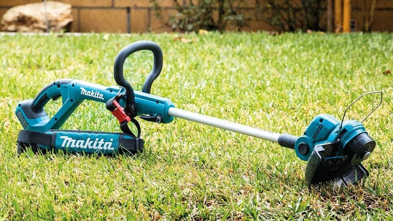 Makita string trimmer laying in the grass