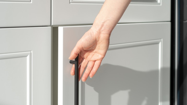 woman opening kitchen cabinet