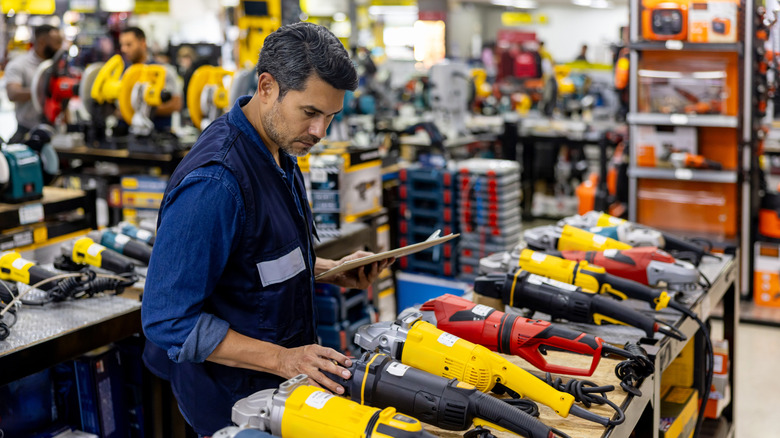 A man looks at a variety of power tools for rent