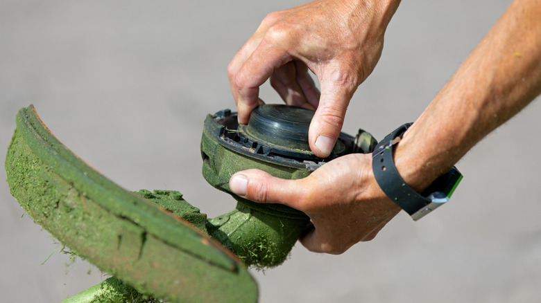 A man changing the head on a weed eater
