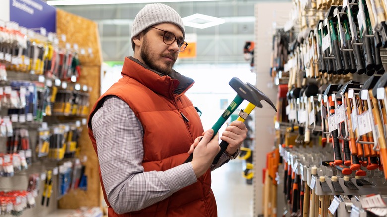 young man shopping for hammers