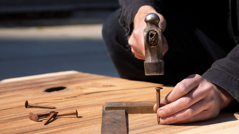 carpenter using ball peen hammer
