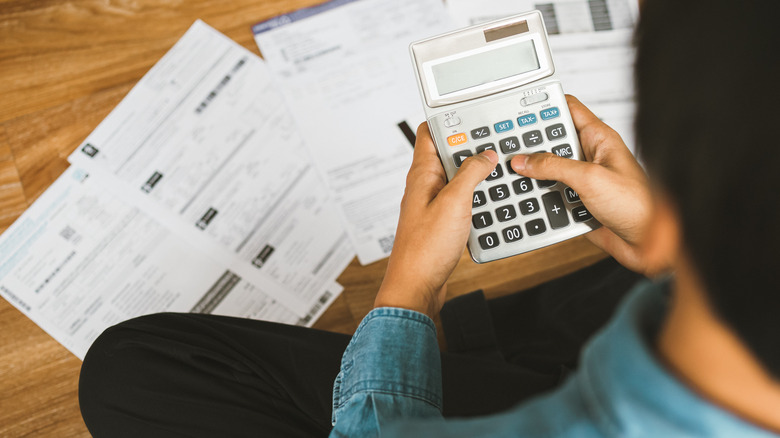 person sitting on floor with calculator
