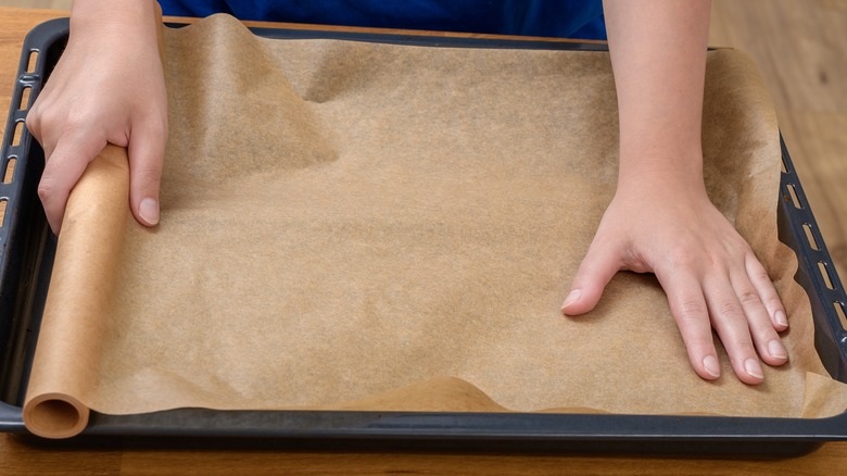 Person lining baking sheet