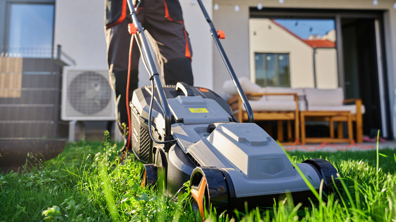 A person using an electric lawn mower