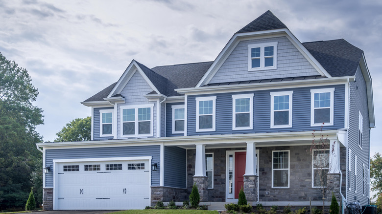 Home with stone veneer and vinyl shingle and horizontal siding