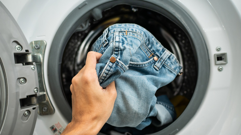 putting clothes in washing machine