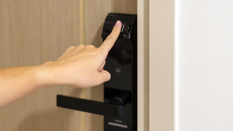 Person scanning fingerprint on doorknob