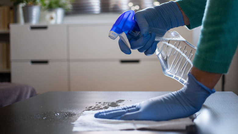 person cleaning with spray bottle