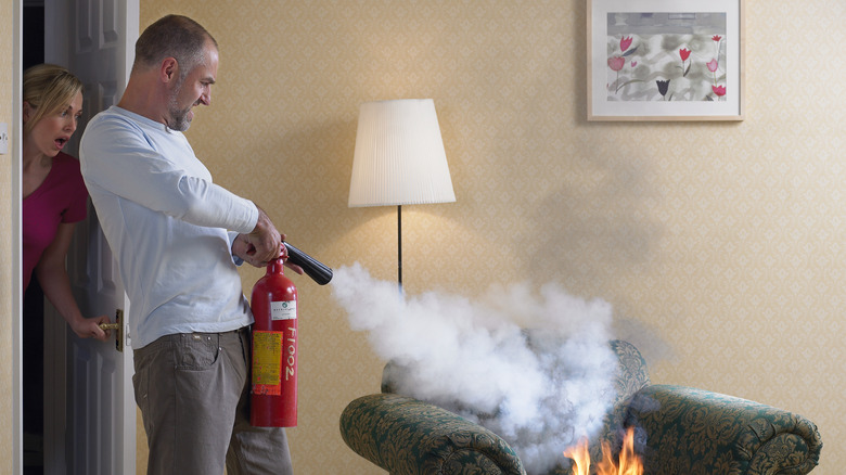 man using extinguisher to put out fire