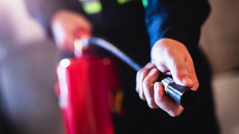 hand pointing fire extinguisher