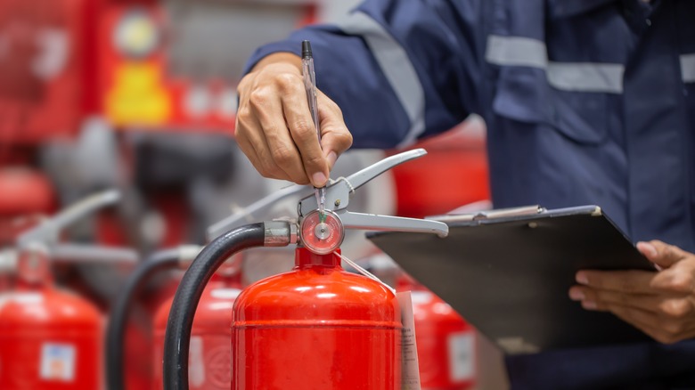 person inspecting fire extinguisher
