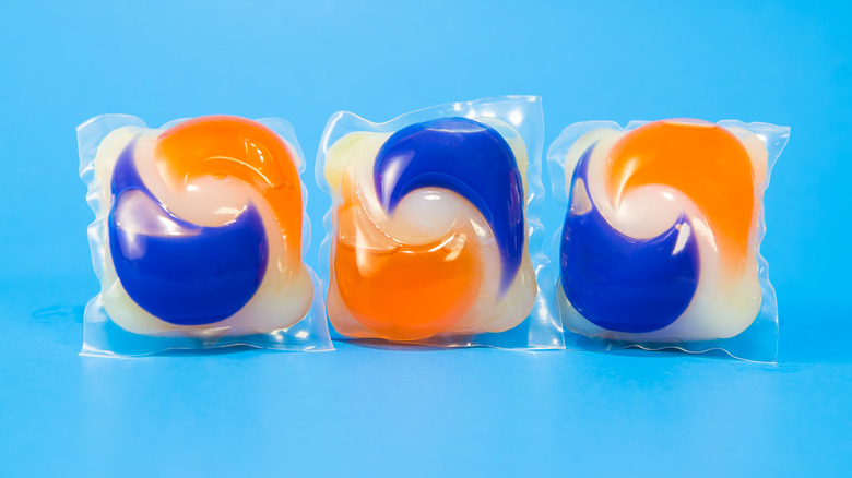 Three dishwasher pods on blue background