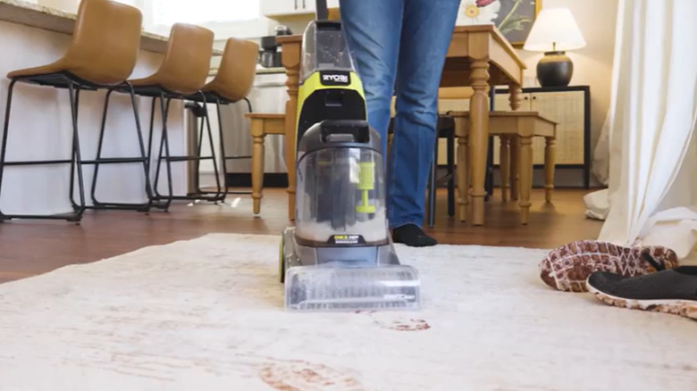person cleaning footprints on carpet with Ryobi tool