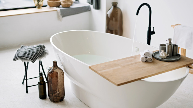 white bathtub with black faucet