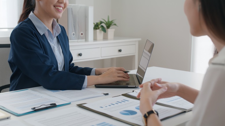 women sitting with laptop and graphs