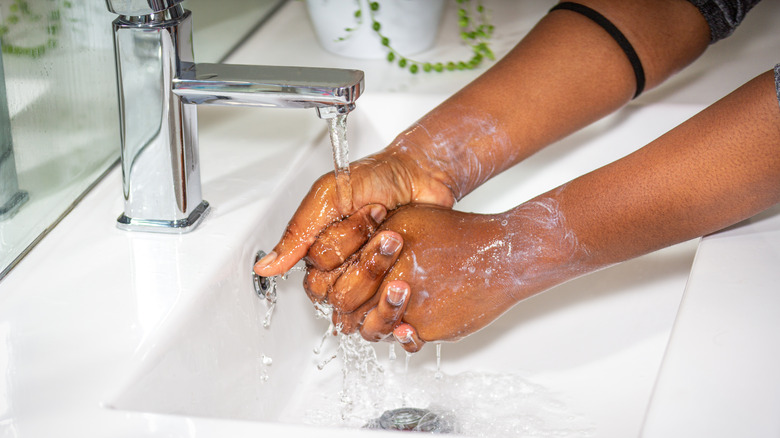 woman washing hands in sink