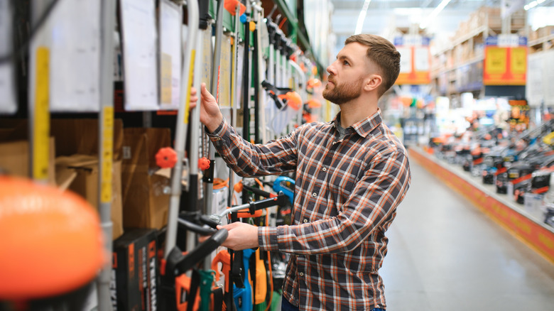 Someone shopping for lawn tools in a store