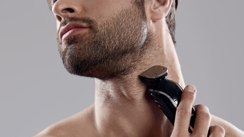 man shaving beard with trimmer