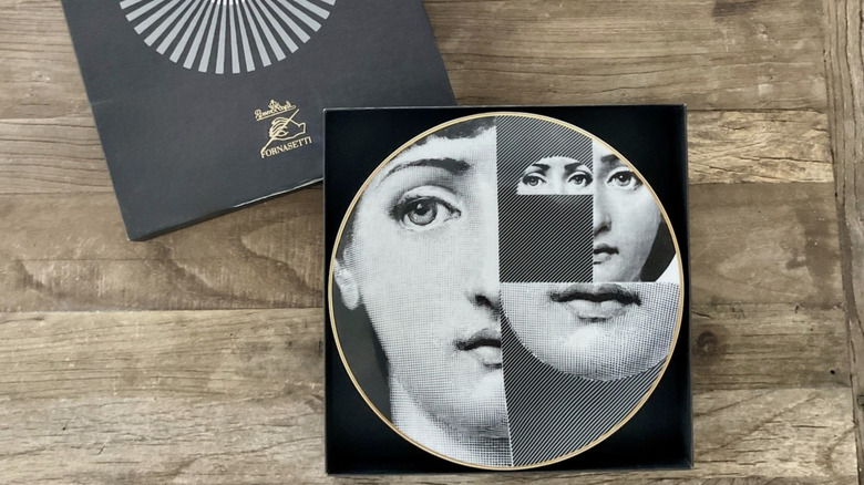 Piero Fornasetti decorative plate on a wooden background