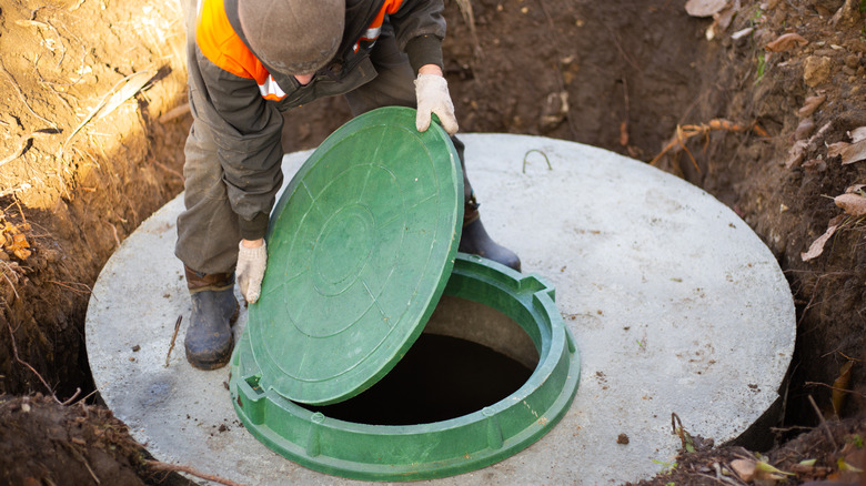 A worker installs a riser on a septic tank so it is easily accessible in the future