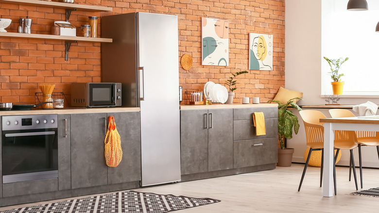 Kitchen with brick wall and sleek fridge