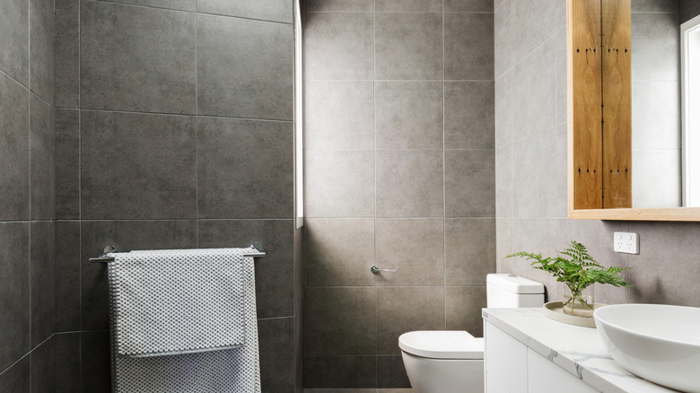 A bathroom with large gray square tiles