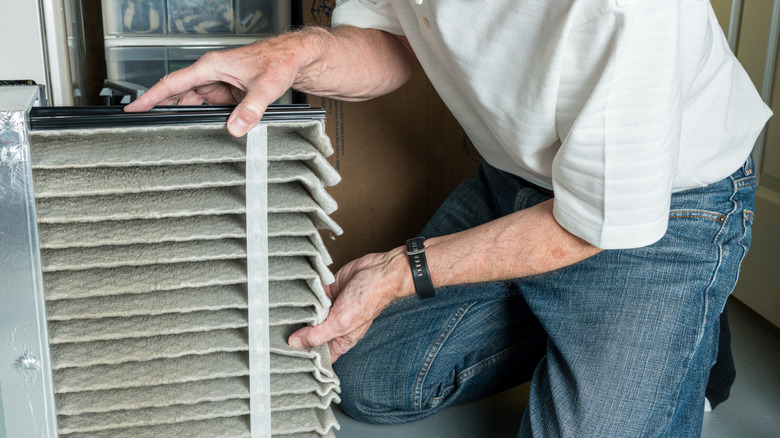Person removing a dirty furnace filter