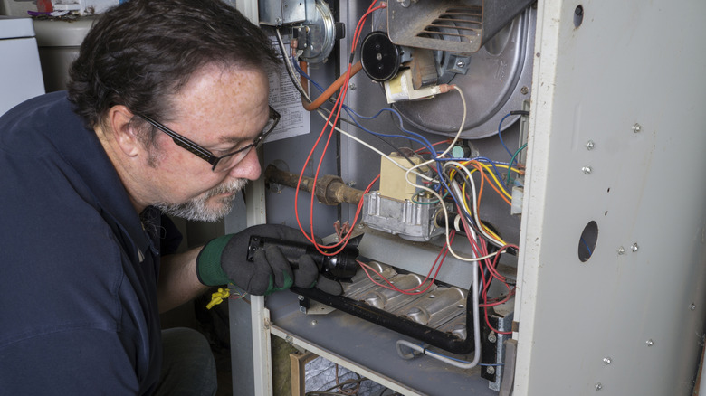 Man cleaning the interior of a furnace