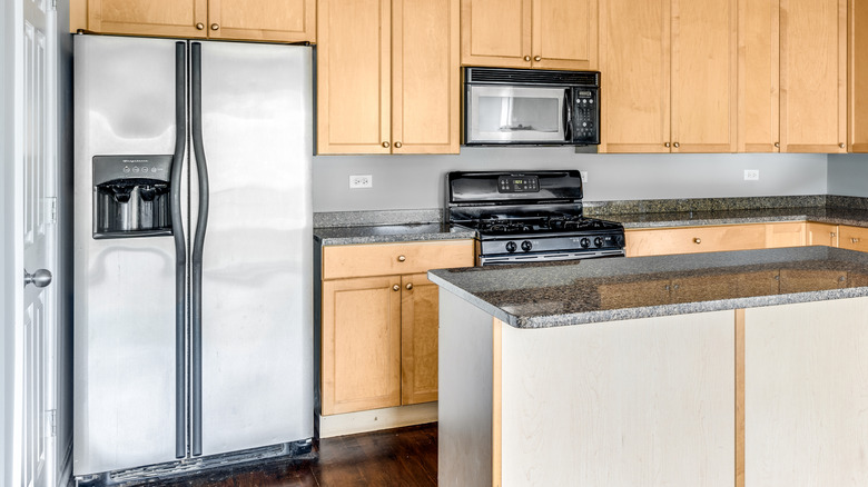 A stainless steel side-by-side Frigidaire refrigerator in a kitchen