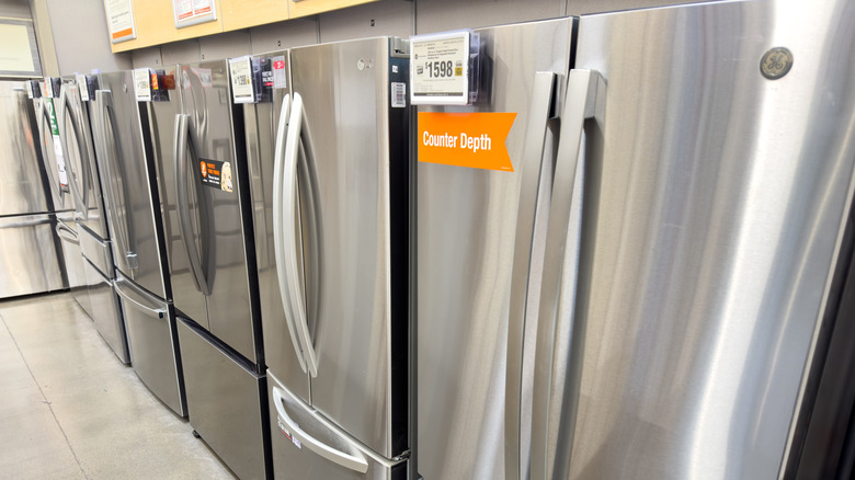 GE stainless steel refrigerators on display inside a Home Depot store.
