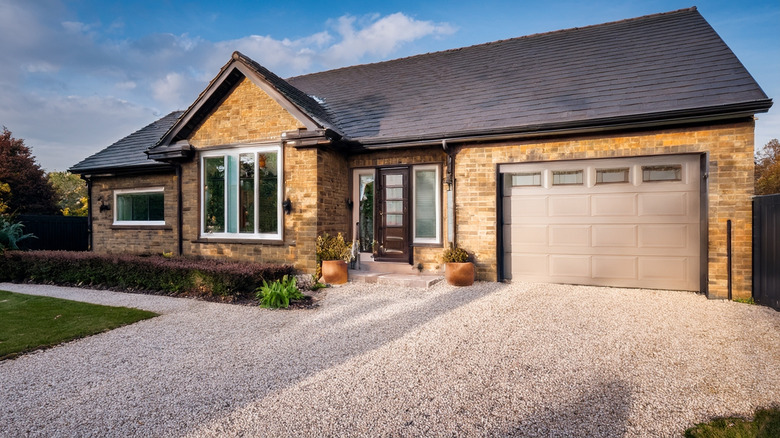 Ranch house with gravel driveway.