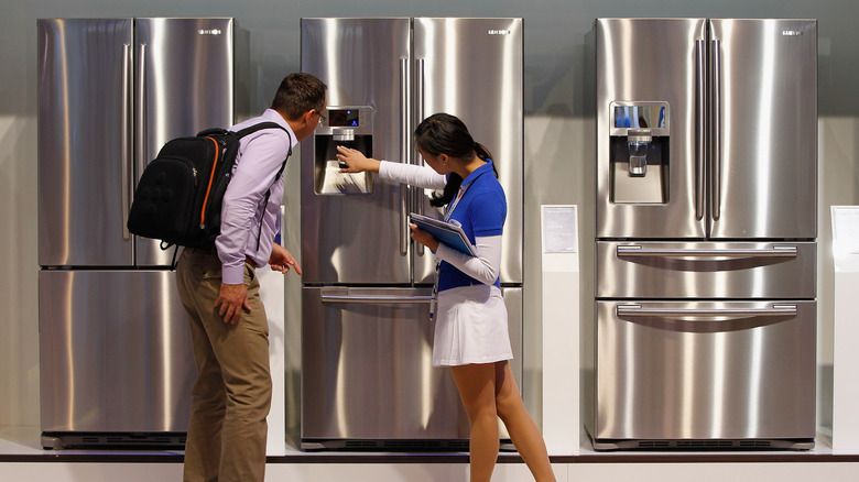 Two people looking at Samsung fridges
