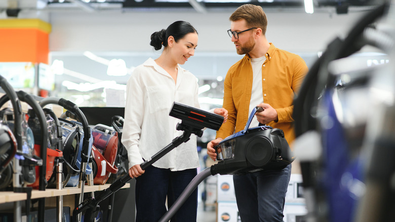 A couple looking at  vacuums in a store