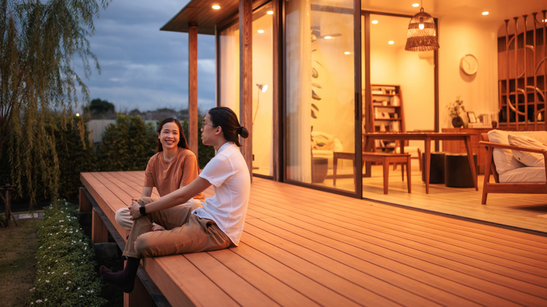 A couple relaxing on a wood deck