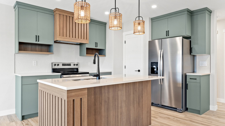 Green wooden cabinets in minimalist kitchen