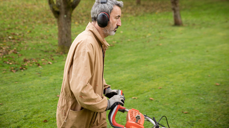 A person mowing their lawn with an electric walk-behind push mower