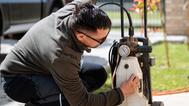 A man adjusting the pressure washer