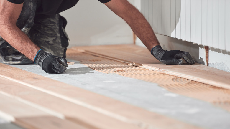 Person laying planks of laminate flooring