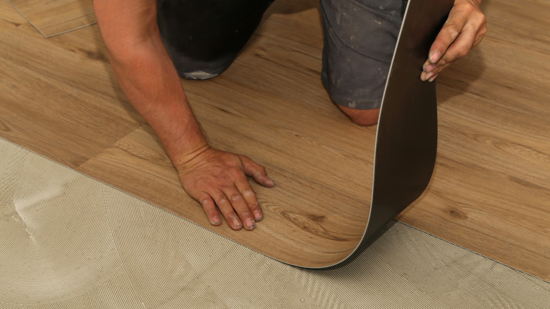 Person installing new vinyl flooring