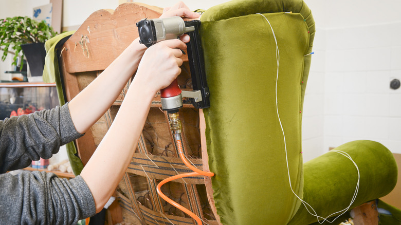 Stapling green fabric to chair