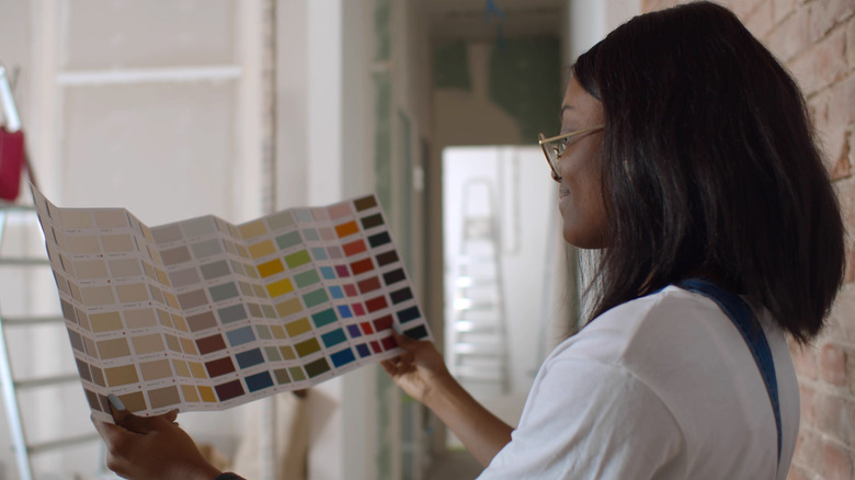 Young woman choosing from paint swatches 