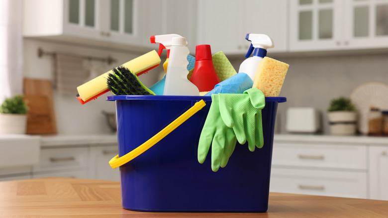 A bucket of cleaning products on kitchen countertop