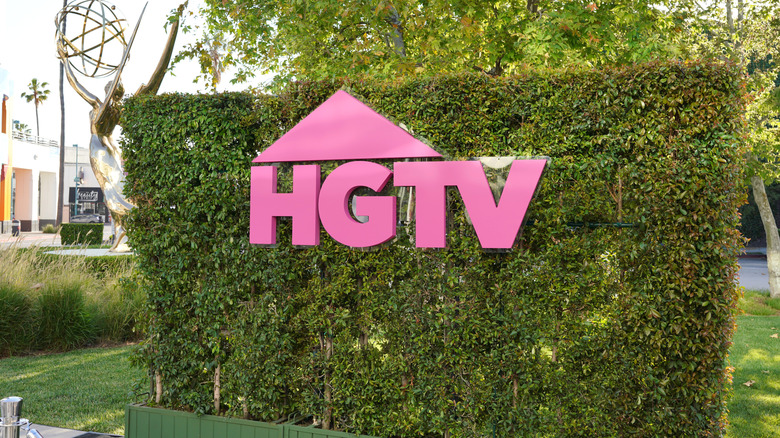 A pink HGTV sign on a hedge