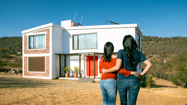 A couple stands in front of their new home